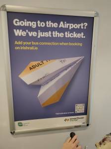 Poster on a train promoting rail-airport connection "Going to the airport? Just the ticket add your bus connection when booking on irishrail,ie"